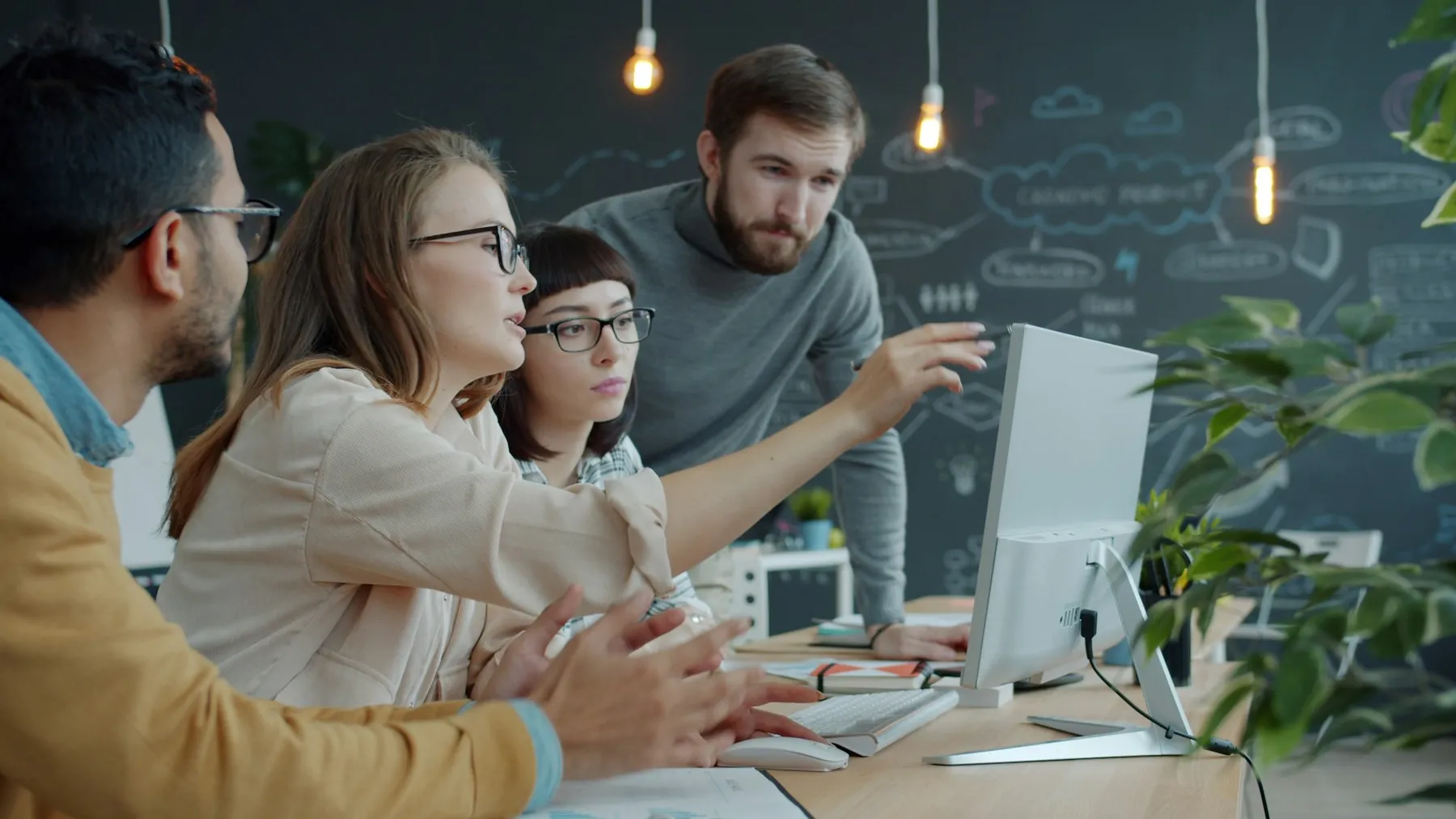 Team members collaborating around a laptop