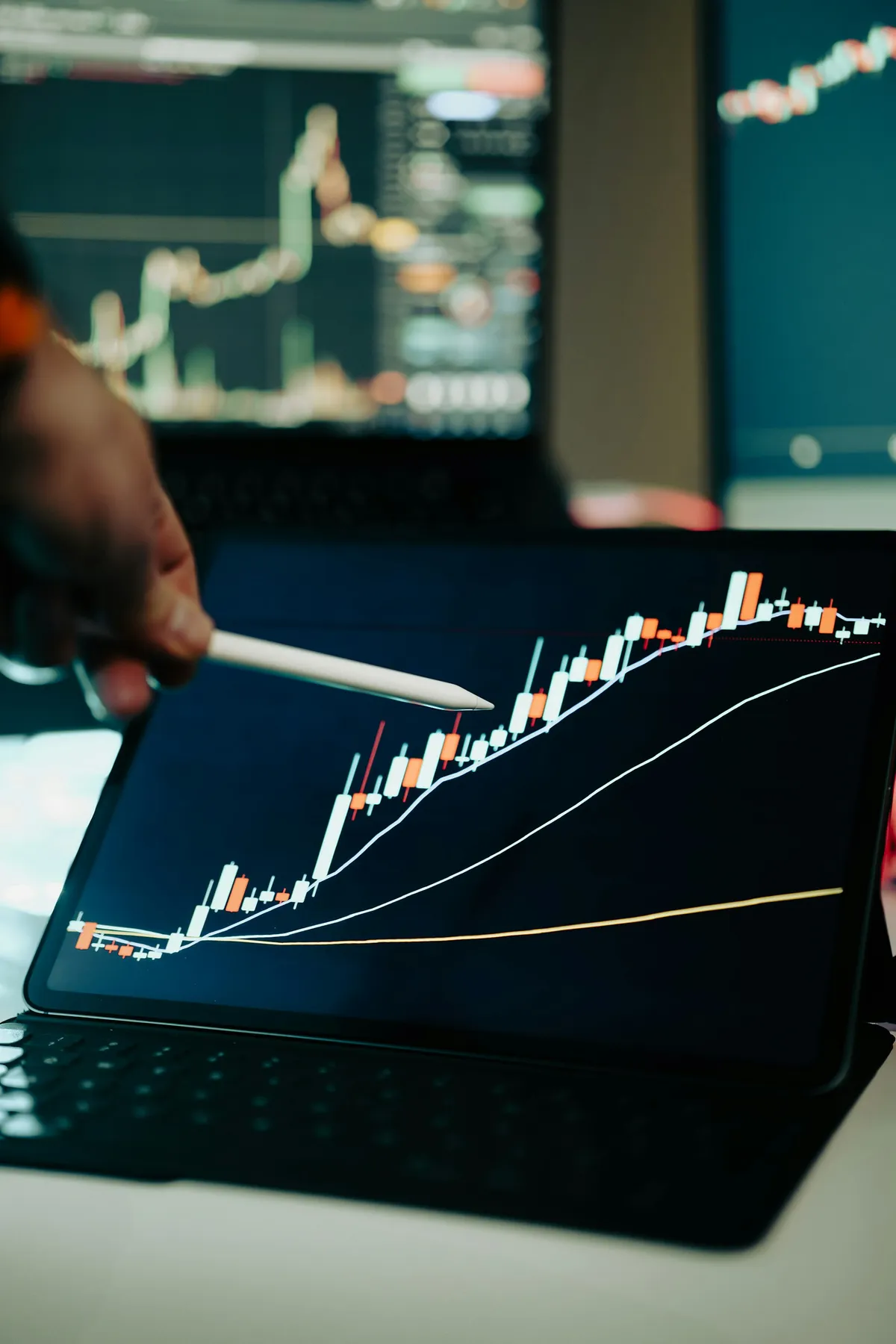 Person pointing at an upward-trending growth chart on a tablet screen Person pointing at an upward-trending growth chart on a tablet screen